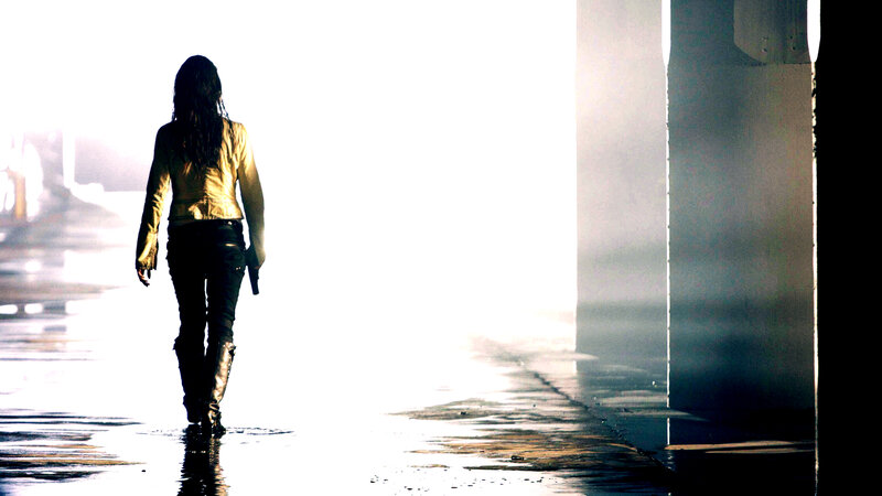 woman walking in rain with gun