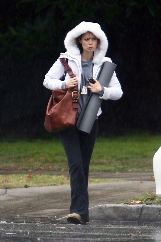 woman walking in rain with yoga mat