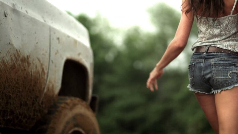 woman walking near muddy truck