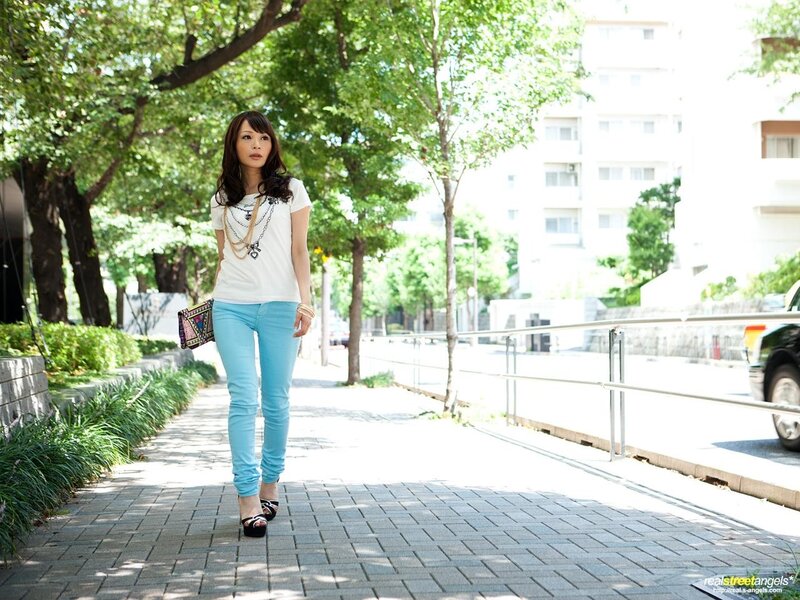Woman walking on a sunny sidewalk