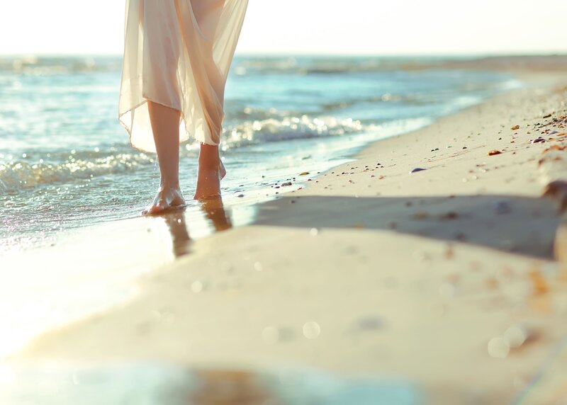 woman walking on beach at sunset