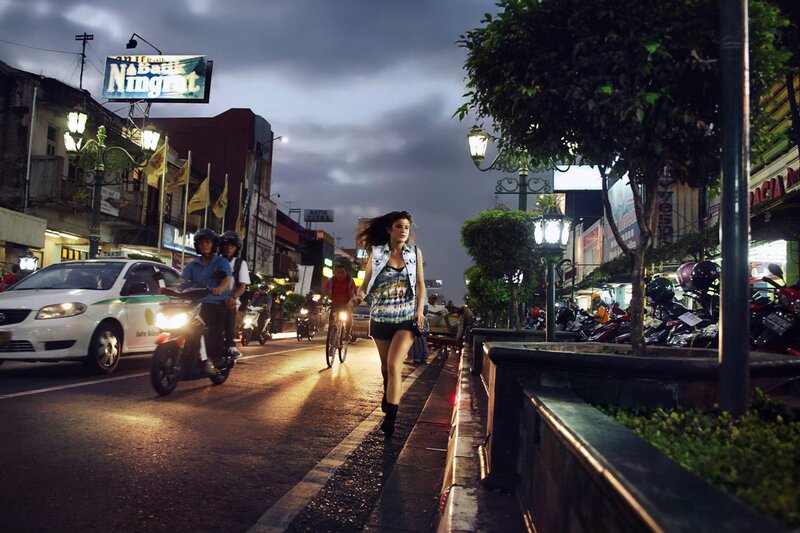 Woman walking on city street at dusk
