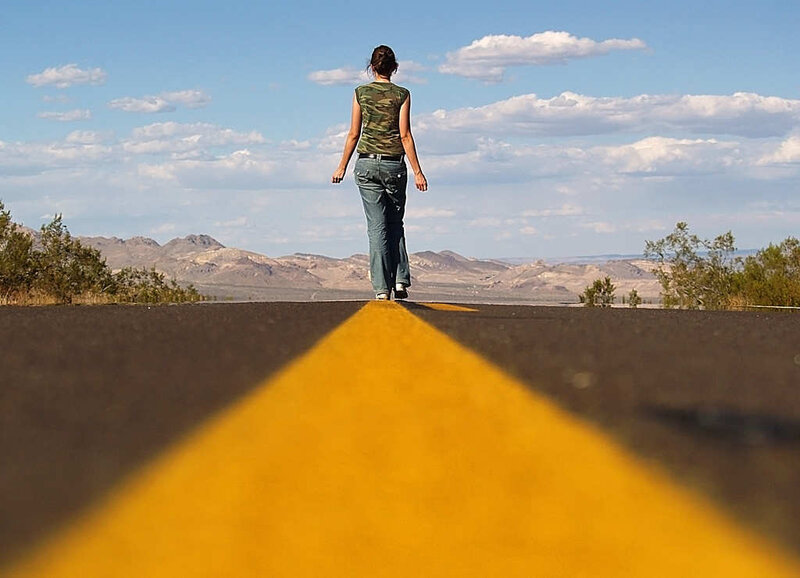 woman walking on desert road