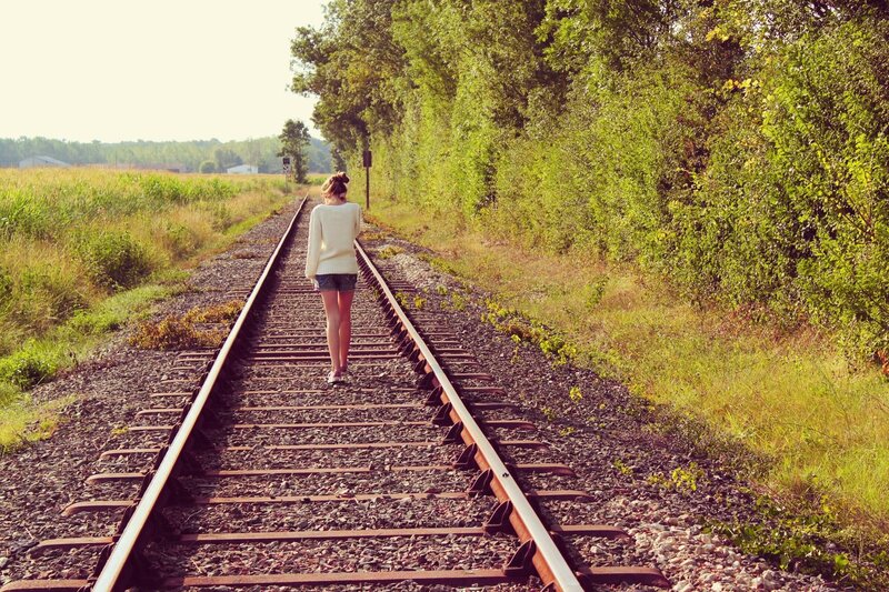 woman walking on train tracks