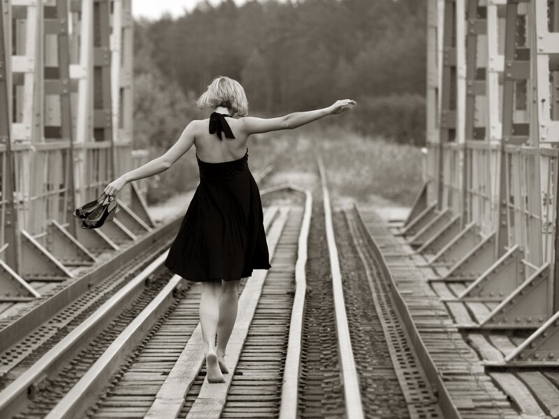 Woman Walking on Train Tracks — Black