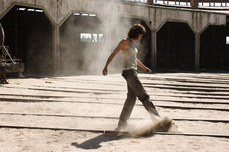 Woman walking through dusty warehouse