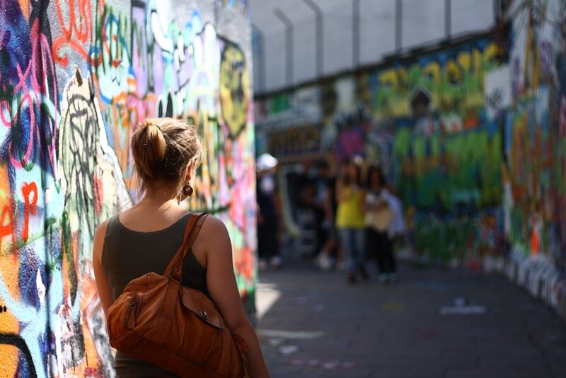 Woman walking through graffiti alley