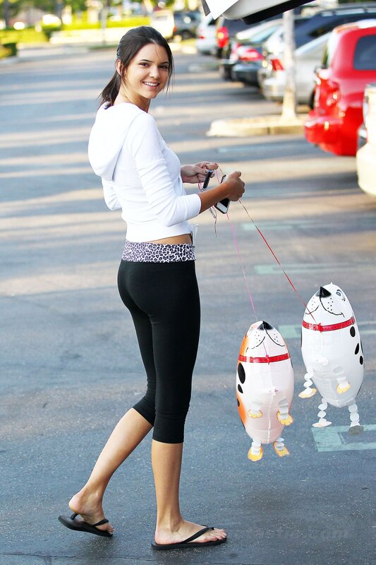 Woman walking with dog balloons