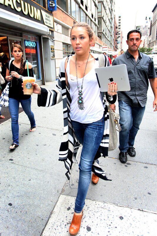 Woman walking with tablet and coffee