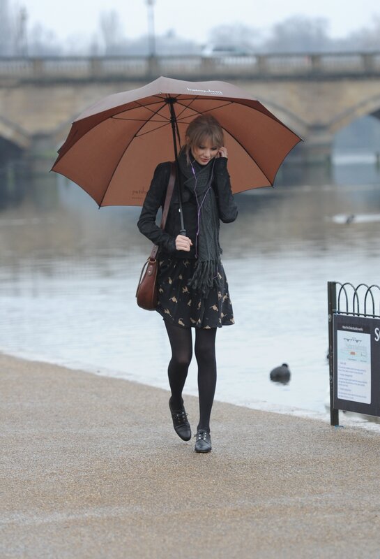 Woman walking with umbrella by river