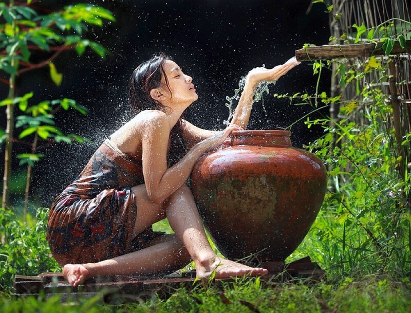 Woman washing with water from a jar