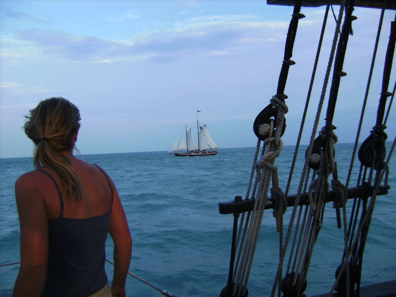 woman watching sailboat at sea