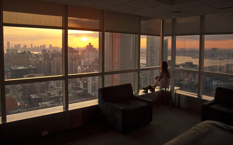 Woman watching sunset from high-rise