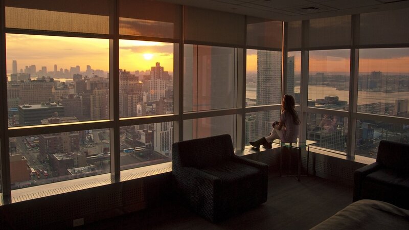Woman watching sunset from high-rise