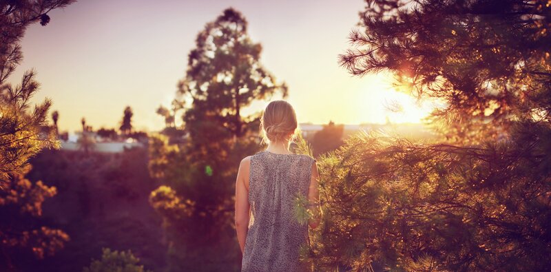 Woman watching sunset in forest
