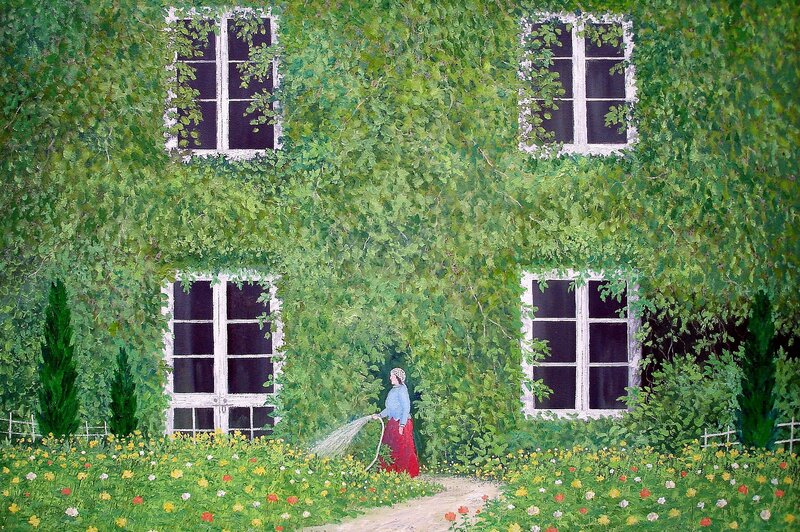 Woman watering garden by ivy-covered house
