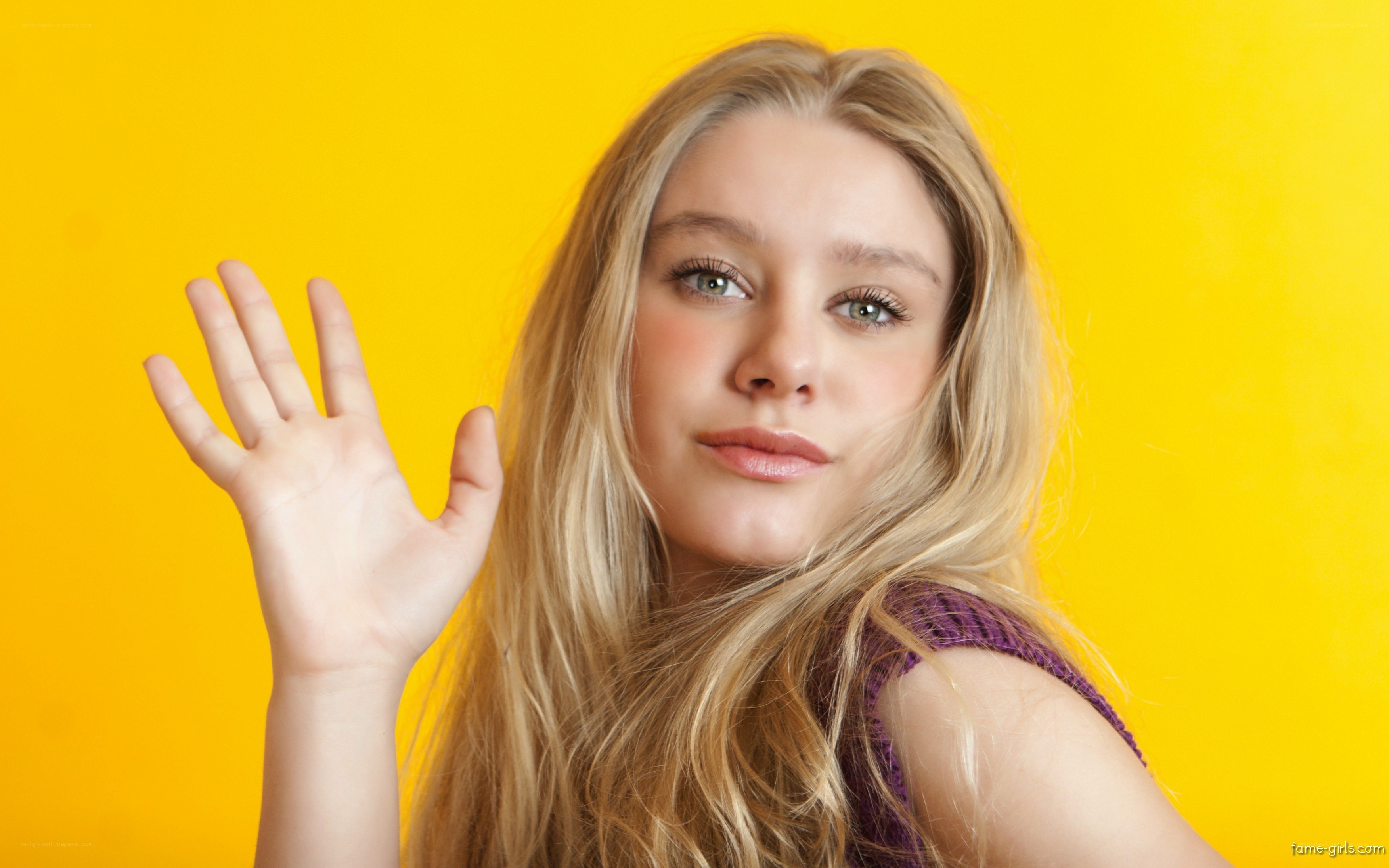 woman waving against yellow background