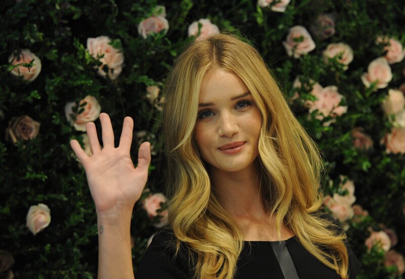 woman waving at flowers