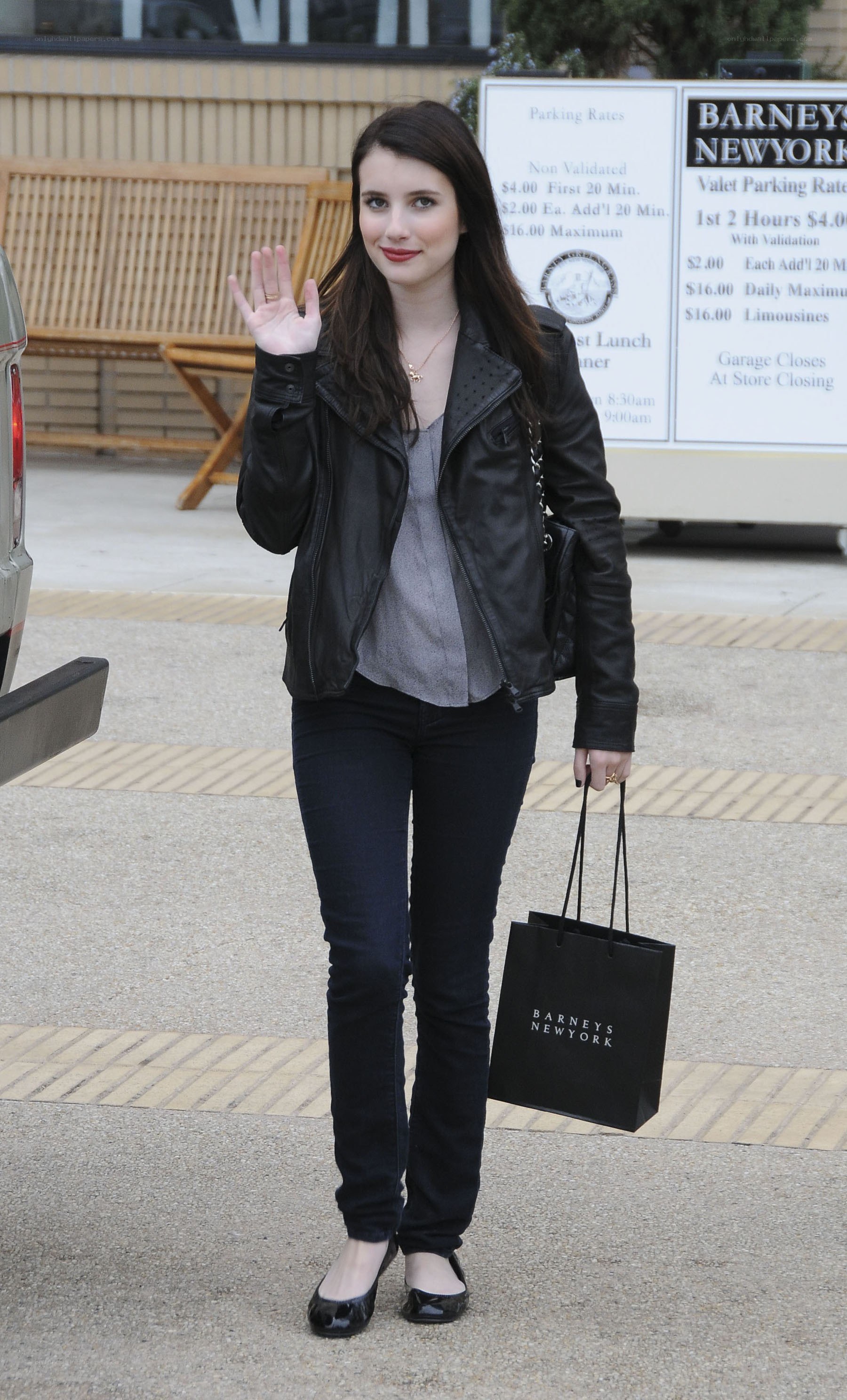 woman waving outside store