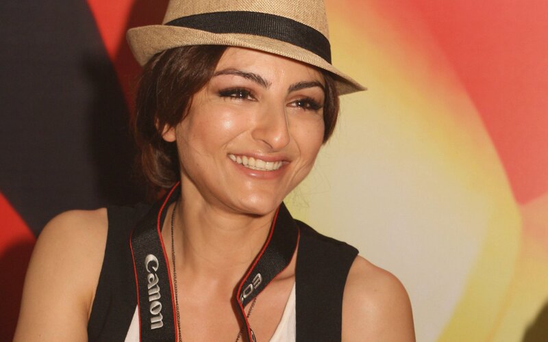 woman wearing a hat and camera strap