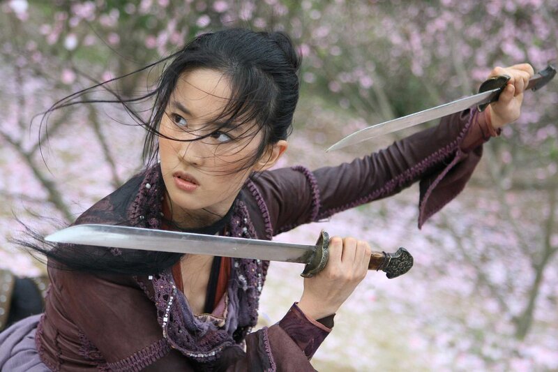 Woman wielding swords in a garden