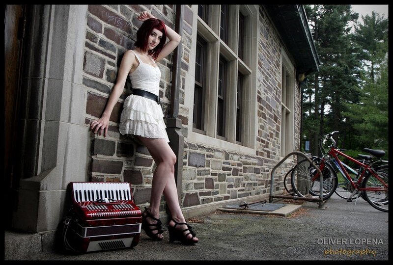 Woman with accordion by stone building