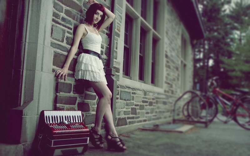 woman with accordion by stone wall