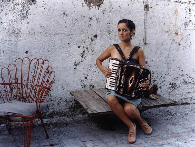 Woman with accordion on bench