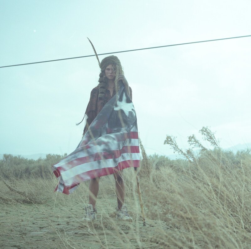 woman with american flag in desert