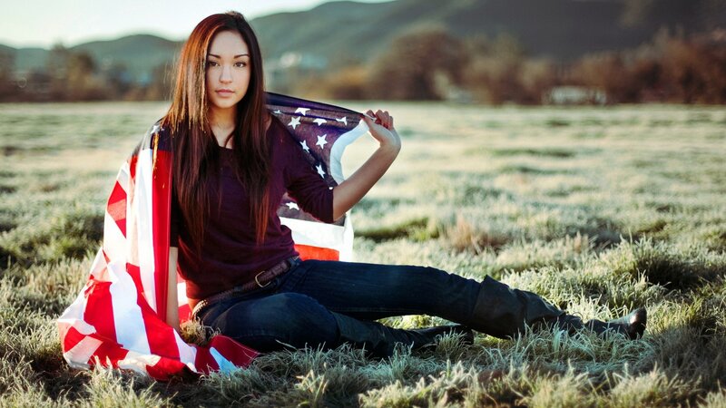 woman with american flag in field