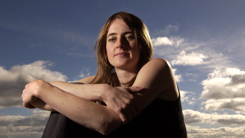 woman with arms crossed against sky