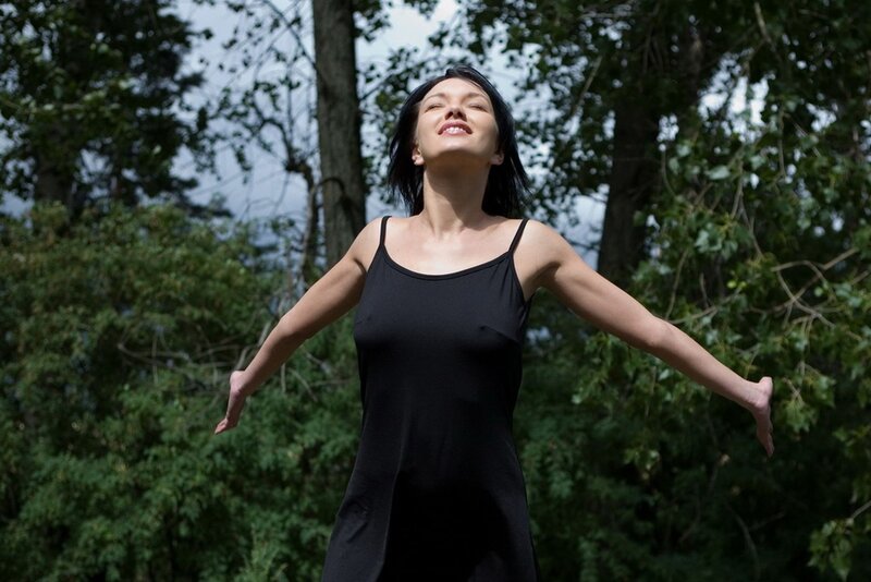 Woman with arms outstretched in forest