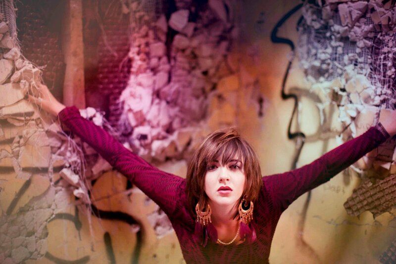 woman with arms outstretched in rubble