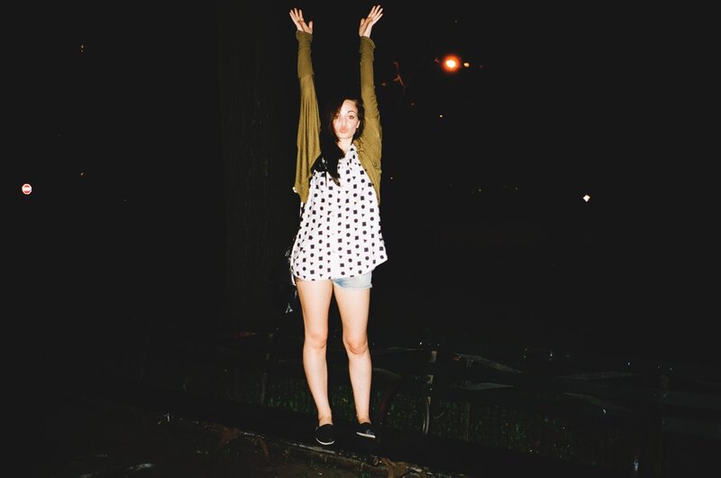 woman with arms raised at night