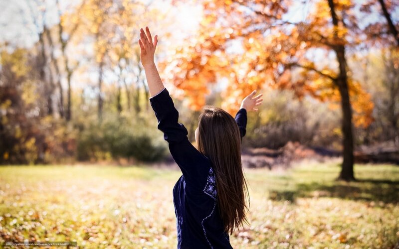 woman with arms raised in autumn