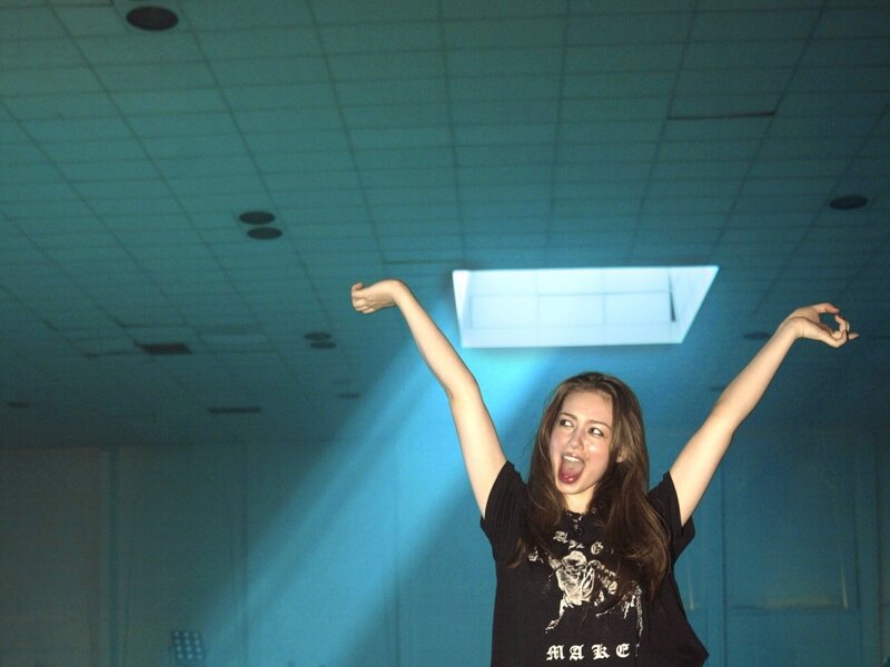 woman with arms raised in light