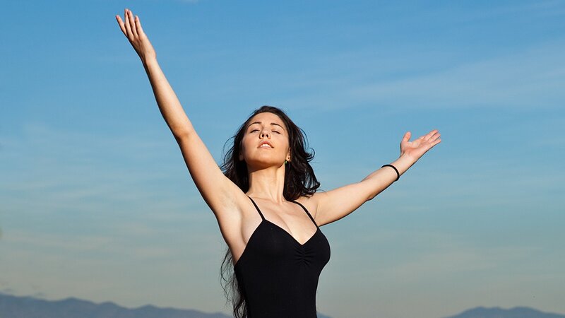 woman with arms raised outdoors