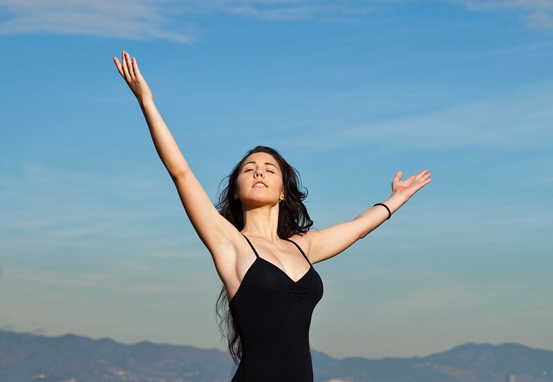 woman with arms raised outdoors