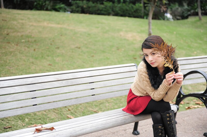 Woman with autumn leaves on bench