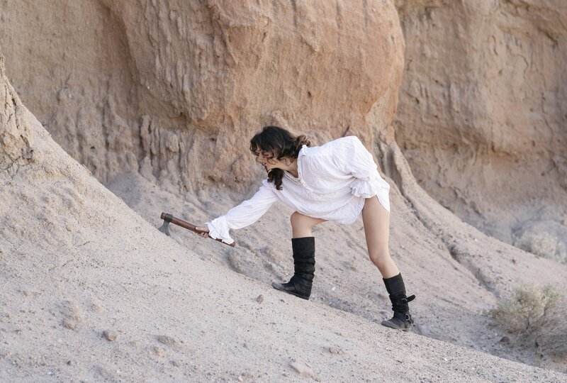Woman with axe in desert