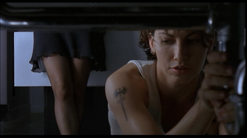 woman with axe tattoo under sink