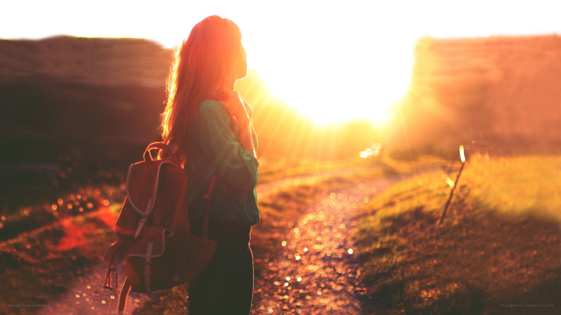 woman with backpack at sunset