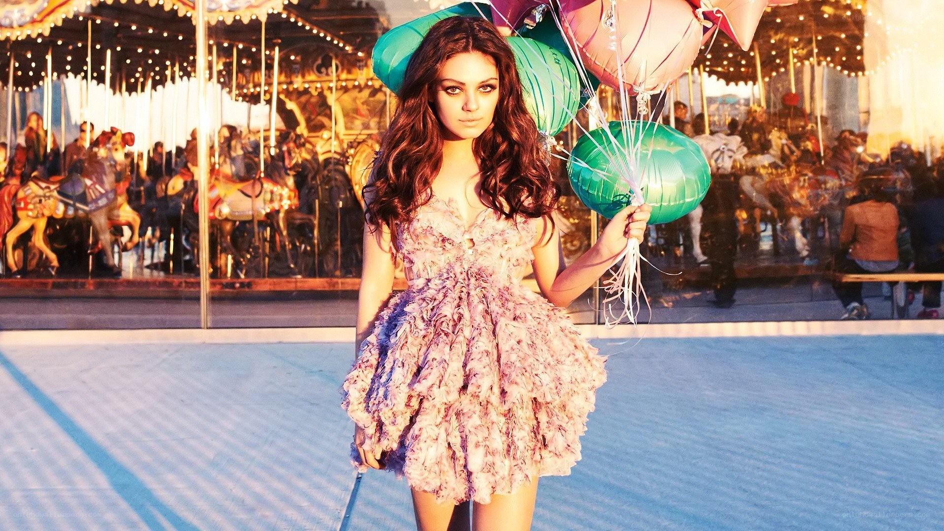 Woman with balloons at carousel