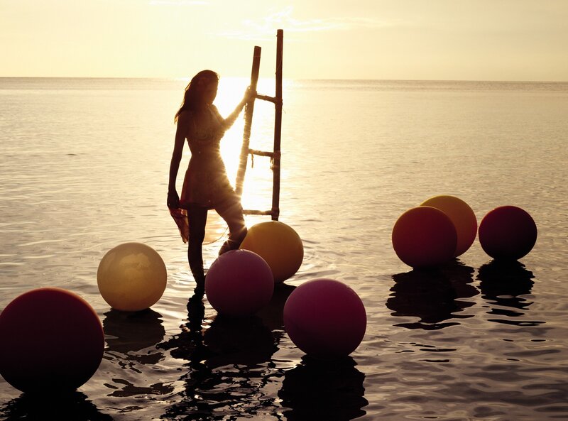 woman with balloons at sunset