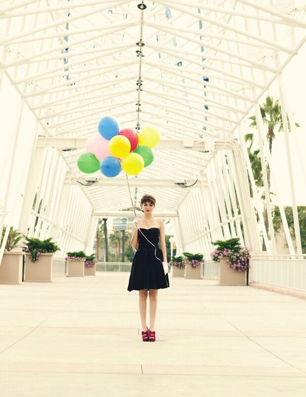 Woman with balloons in a walkway