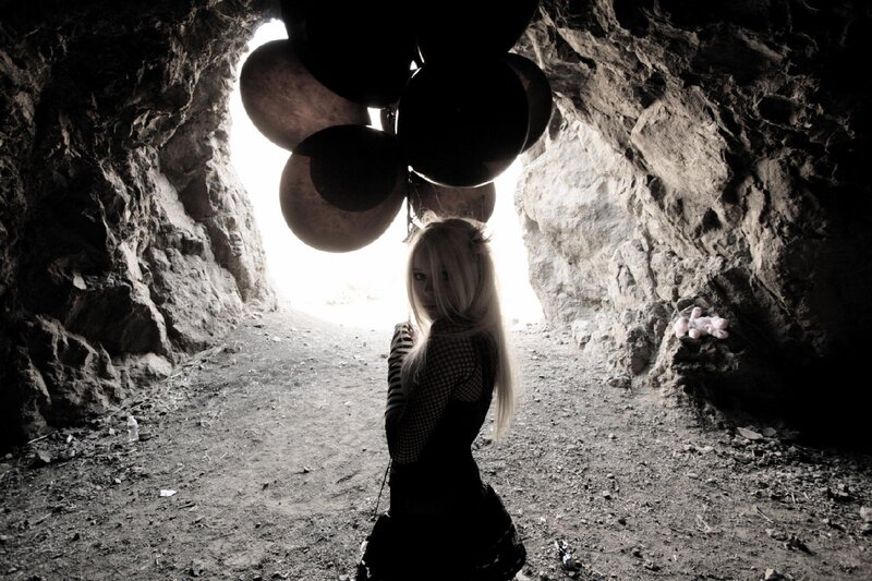 woman with balloons in cave