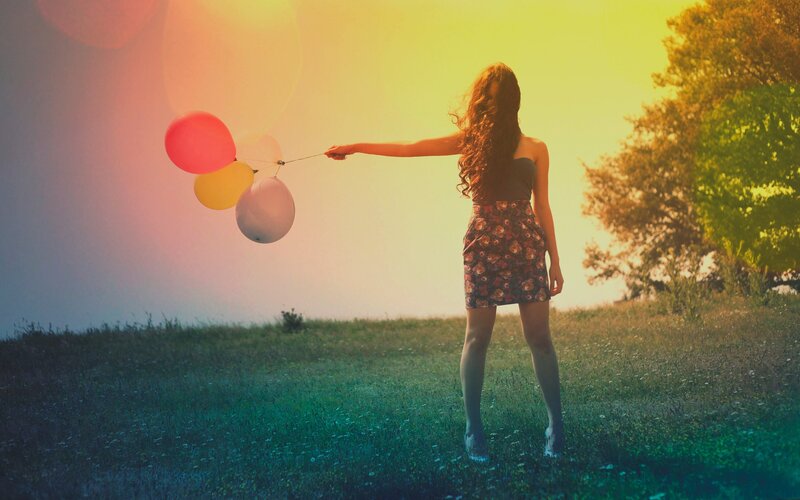 Woman with balloons in field