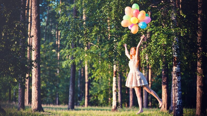 Woman with balloons in forest
