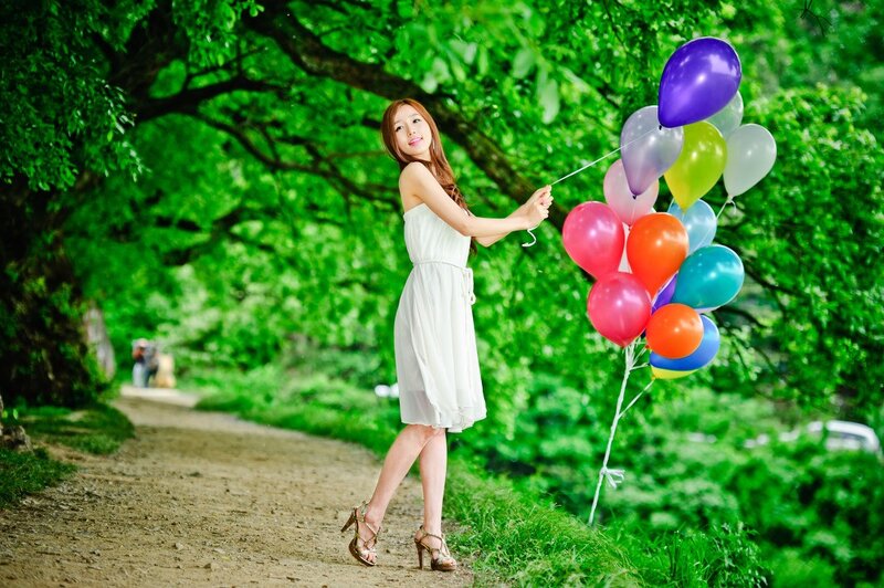 Woman with balloons in park