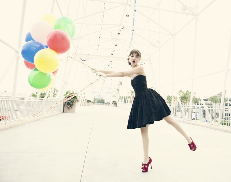 Woman with balloons on a bridge